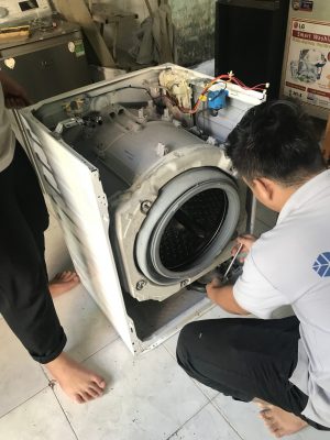 Kỹ thuật viên đang sửa máy giặt